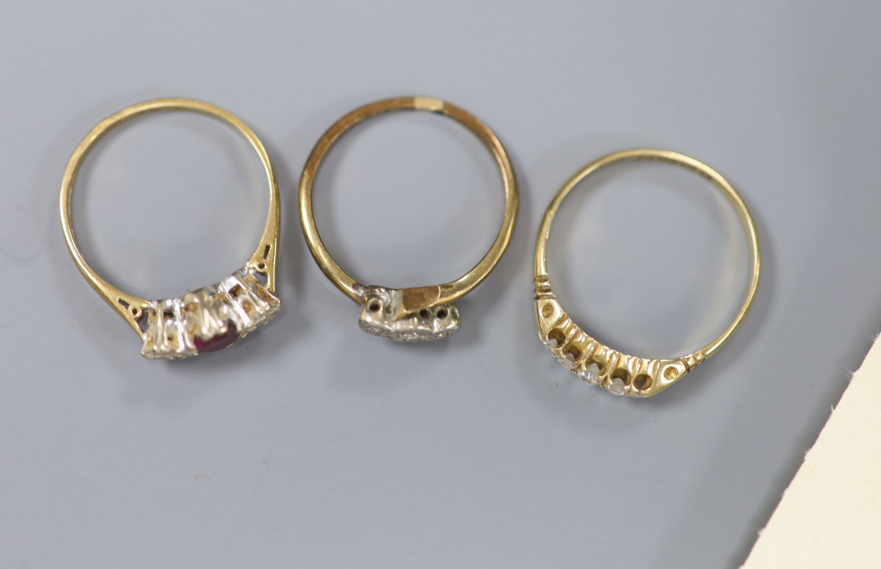 A ruby and diamond three-stone ring, in 18ct gold and platinum setting and two diamond-set rings,